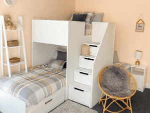 Corner triple bunk bed in white with drawers as storage. Modern decor in kids bedroom.