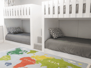Straight Quad Sleeper. sleeping 4 children in one bedroom with stairs drawers and carpet in colour white. Funky Bunk Beds